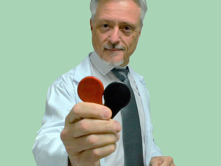 homem segurando um par de imas terapeuticos com a mão direita, oferecendo ao leitor