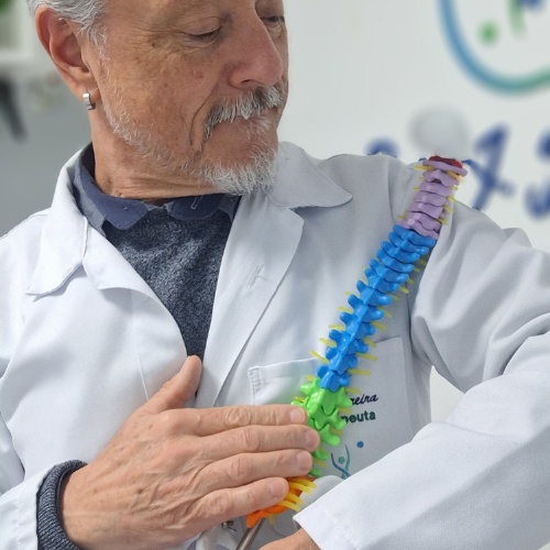 Homem segurando cuidadosamente uma representação da colun vertebral