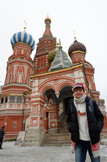A boy standing in front of the St. Basil's Cathedral in Moscow.
