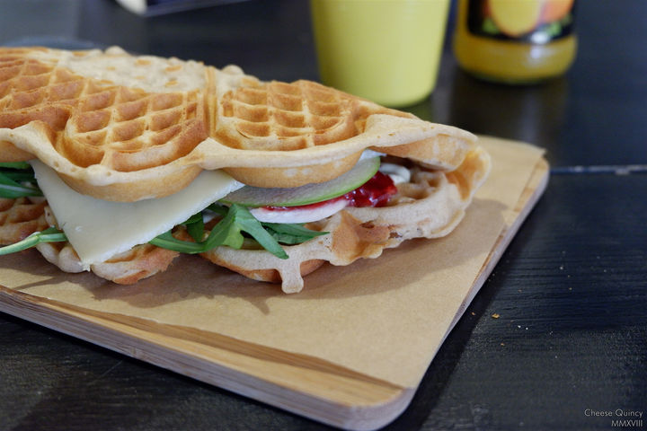Waffle with chicken, veggie, cheese and onion serving on a wood board