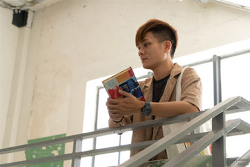 Man holding a notebook, leaning on the stair handrail