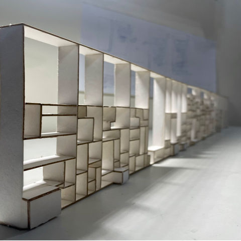 This image presents the physical model of the Waiting Library at the entrance to the Klal Building in Jerusalem, next to the light rail station. It illustrates the internal organization of personal lockers, seating areas and a small kitchenette. The warm design conveys the combination of functionality with a pleasant atmosphere that allows visitors to wait comfortably.