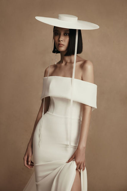 Moore - sheath mermaid wedding gown with lowered shoulders. A dress is embellished with falbala that passes to the back of the dress, where the weightless tulle cape that adds elegance is attached. A sheath soft skirt features a small chapel train.
