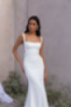 Our SYDNEY wedding dress from Evie Young epitomises class and opulence. The light crepe fabric creates an elegant, body-hugging fit and a statement of simplicity and refinement.

Delicate pearl bead trim enhances the thoughtful construction of the gown which becomes the focal point of this creation – a unique idea for brides seeking to showcase their subtle, refined and sophisticated style. The pearls adorn the bodice, shoulder straps, waistband, and flow down the sides of the skirt to the floor.

The simplicity of the square neckline is perfect to enhance a sentimental love locket. The back of the gown creates another ‘moment’ with a stylish pearl embellished tulle godet.

For comfort and ease of movement, SYDNEY is lined with stretch jersey lining and is fitted with internal boning and bust cups. SYDNEY stuns and flatters in sizes 2 to 28, with an optional matching Sydney veil which can be purchased separately.