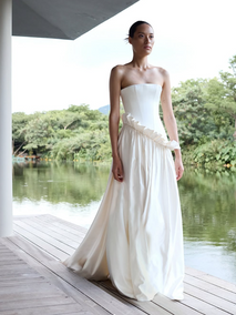 Ruffling the sartorial status quo in Lotus. Introducing a new and luxurious creamy silk satin, Lotus features a modern straight neckline, structured, drop waist bodice and an asymmetric a-line skirt with a high-impact gather. For the fashion-forward amongst us, Lotus boasts a unique a ruffle detail - optional but highly recommended.

COMING SOON