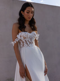 Archie is for our modern-day romantics - for new century Juliets and their Romeos. Luxurious European chiffon featuring sequin and embroidered lace motif fabric provokes enchantment and whimsy. Whilst the demure sweetheart illusion bodice with exposed boning offers a hint of seduction. Matching lace straps falling softly over the arms are removable to create different day and evening looks. The soft and flowy skirt is understated simplicity accentuating the lace bodice. Waist pleats add fullness, allowing the fabric to fall effortlessly to the floor and into a 24” train. Whilst the right leg split offers a hint of flirtatiousness.
The gown's soft stretch charmeuse lining ensures comfort is maintainable all day long. Whilst the 13-piece boning and cups construction guarantees that you feel confident, supported and at ease throughout the day. Archie is perfect for a destination bride who is after a simple shape and loves the allure of a laced bodice.
ORDER OPTIONS
EY486LN – front bodice lined
EY486NS – no skirt split
EY486LNNS – front bodice lined, no skirt split