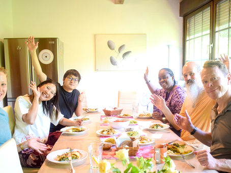 Happy people gathering around a dining table before they eat lunch