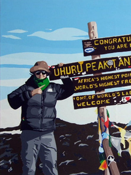 Hiker standing by the sign at the top of Mount Kilimanjaro