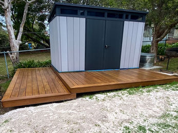 Backyard shed installation with finished deck