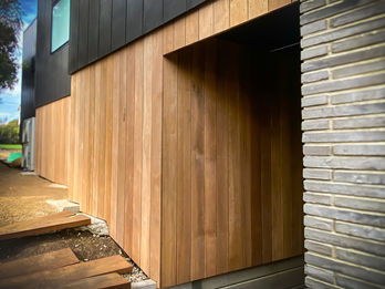 Vertical timber cladding with stone wall