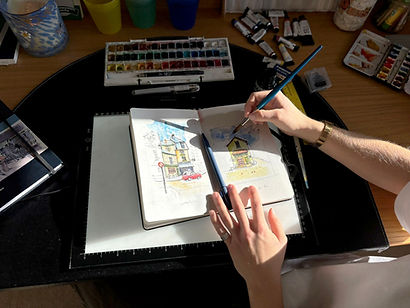 Photo looking from above at Lucy painting a picture.