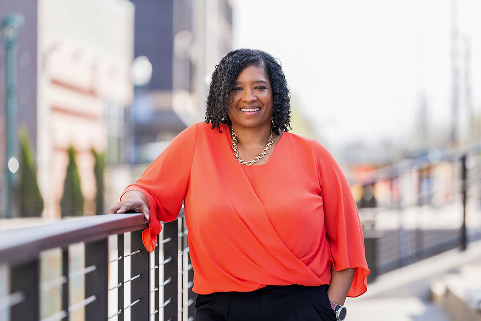 owner TaKiesha smiling in orange top outdoors