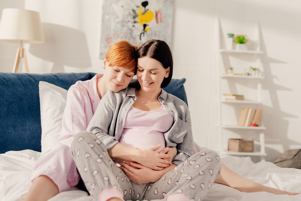 Pregnant woman on bed with partner embracing her