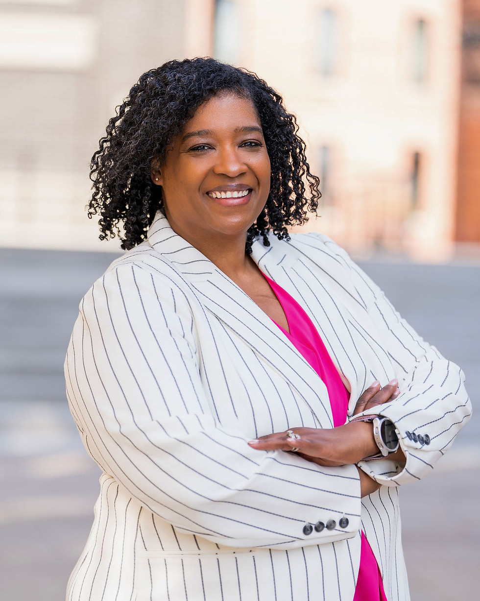 owner TaKiesha smiling wearing a striped blazer