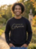 Saved By Grace black Christian sweatshirt with gold lettering on female model outdoors