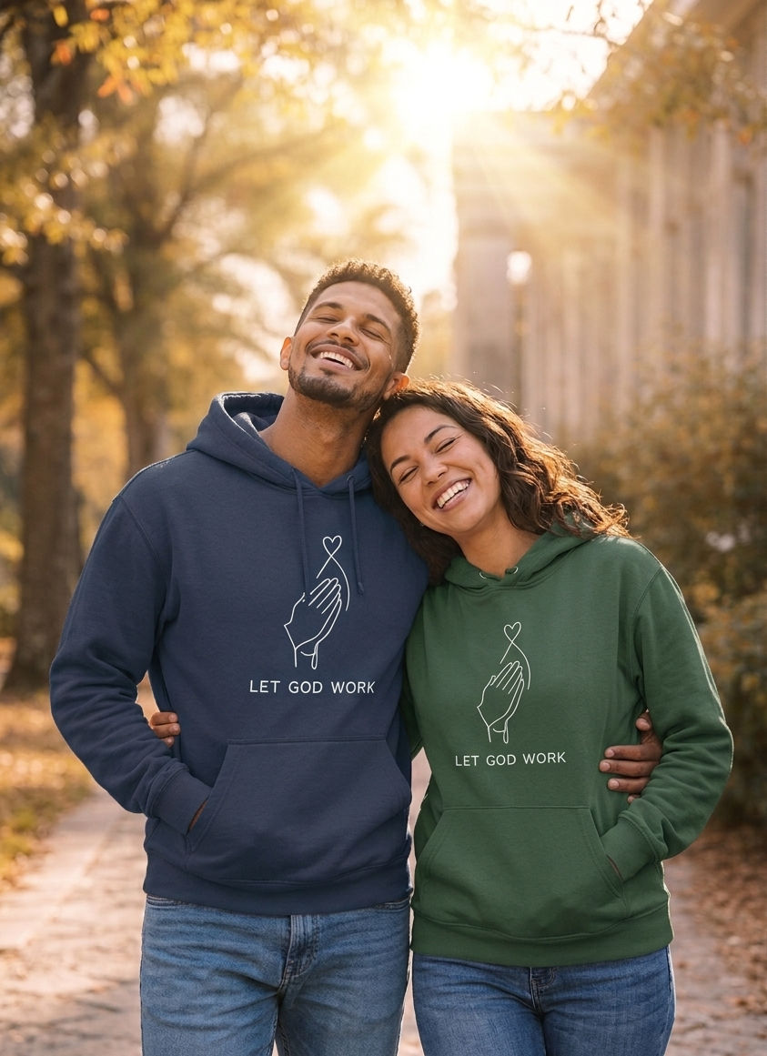 Thumbnail: Couple wearing forest green and navy Let God Work Christian hoodies in outdoor setting