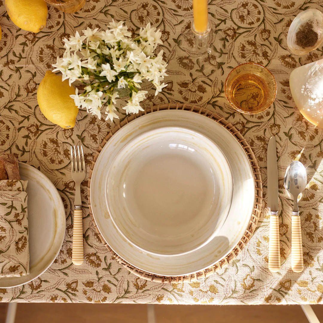 Assiette en grès Neptune Amberley présentée sur un plan de travail JustKitchens, mettant en valeur une table élégante et artisanale.