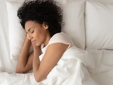 Adult lying in bed experiencing difficulty sleeping