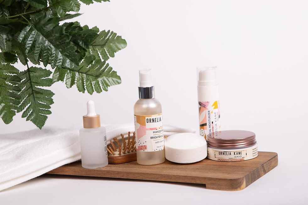 Ornelia Kane Skincare products on a wooden tray, including bottles and jars. Greenery in the background, creating a fresh, clean setting.