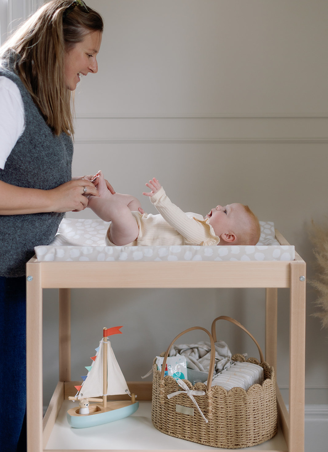 Overhead view of a changing mat with nappies, wipes, cream and nappy sacks in a nursery organiser.