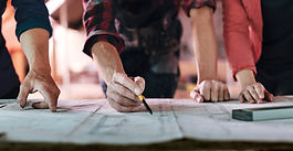 Entrepreneur sketching out a business plan and wireframe on a notebook at a desk