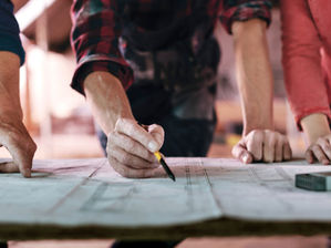 Business team reviewing architectural plans on a table, symbolising structure and preparation for AI readiness in small business.