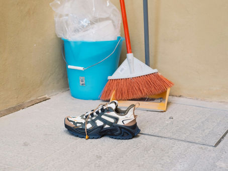 Loose footwear and cleaning equipment left on the floor in a residential setting, illustrating an environmental trip hazard documented through photo reporting.