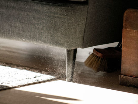 Dust under a lounge in a residential home, illustrating the importance of NDIS-funded cleaning support for maintaining safe and stable housing.