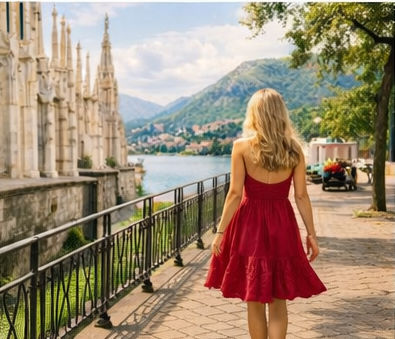 woman in red dress walking by the water in italy during the summer