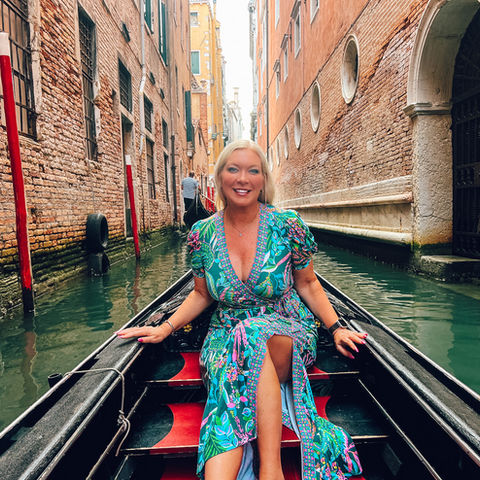 blonde woman on gondola in venetian canal