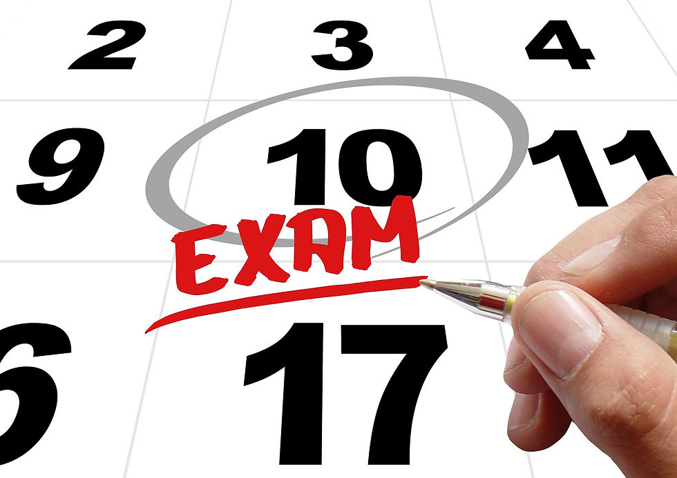 hand marking exam date on calendar with a pen