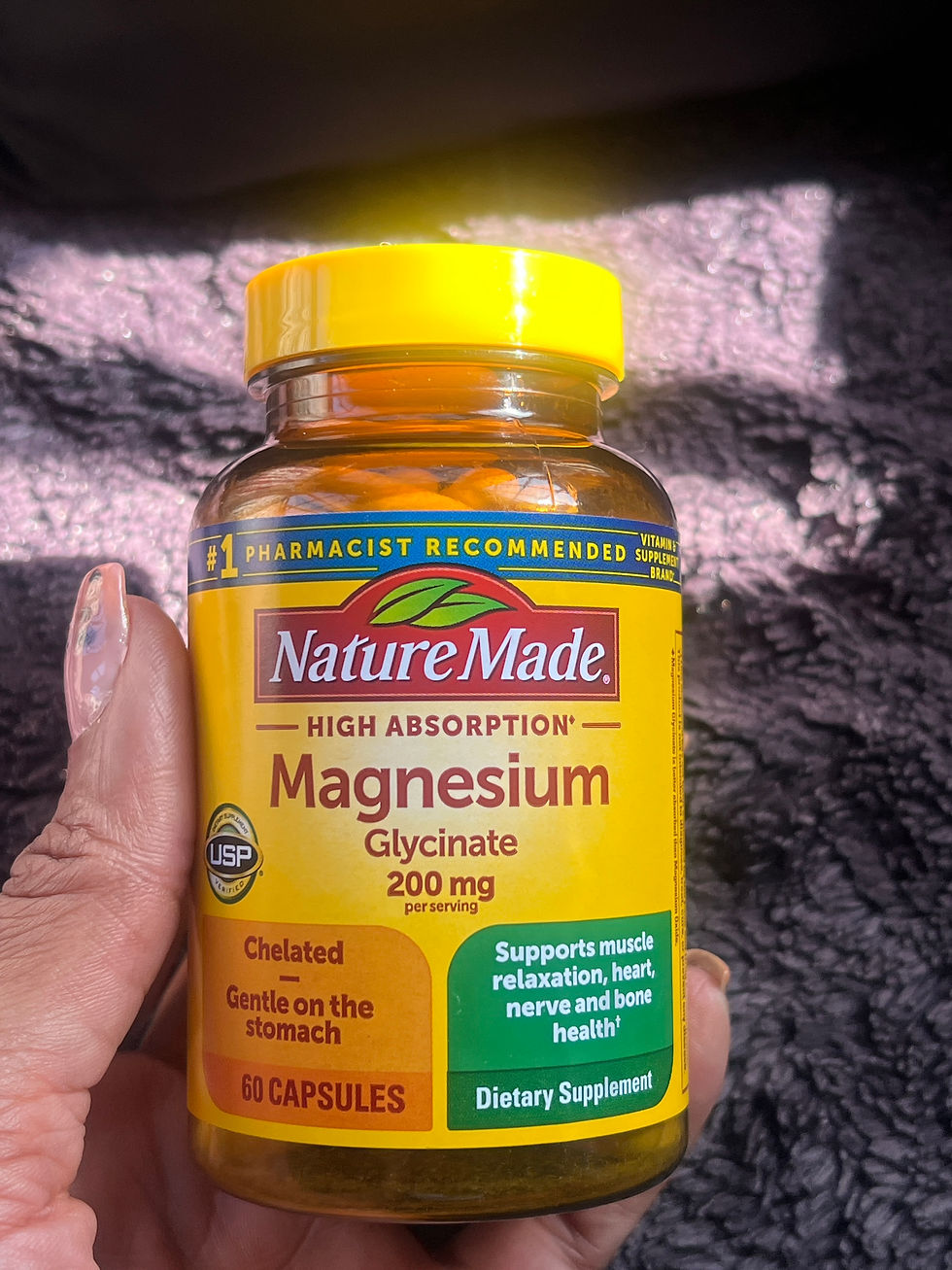 Hand holding a yellow Nature Made Magnesium Glycinate supplement bottle, label visible against a dark textured background.