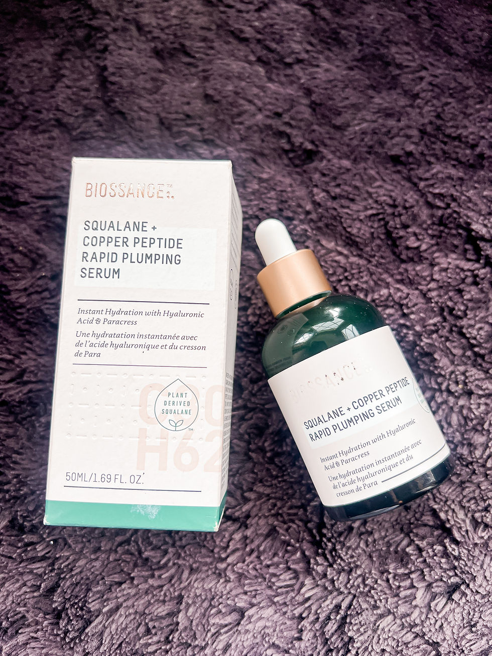 Biossance Squalane + Copper Peptide Rapid Plumping Serum box and dropper bottle on a purple plush towel.
