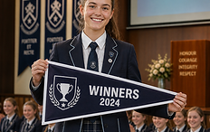 Female student in school uniform holding a winners pennant during assembly with students applauding in the background