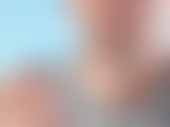 A person holds a blue pill with "100" engraved, against a blurred light blue background. The mood is neutral.