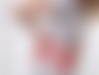 Person in a white shirt clutching their side, highlighting red pain area; blurred background, conveying discomfort.