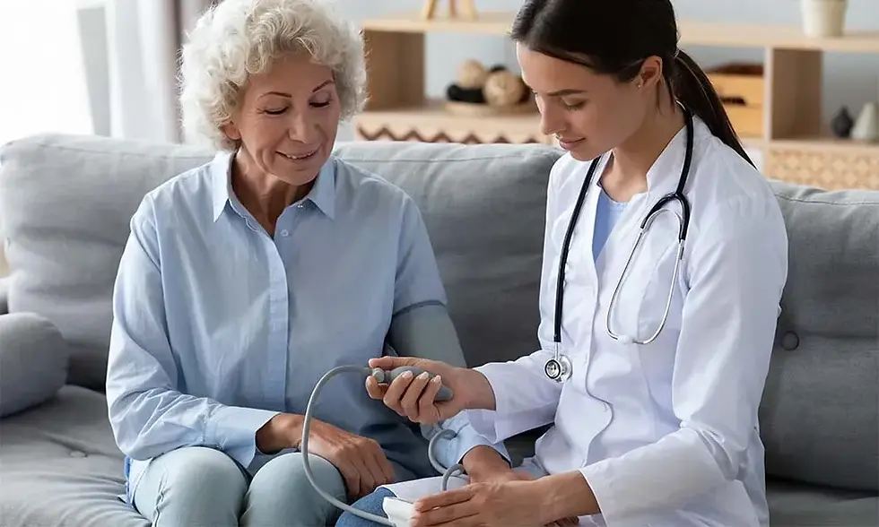 Elderly woman and doctor on a couch, checking blood pressure. Doctor in white coat, stethoscope; calm, professional setting.