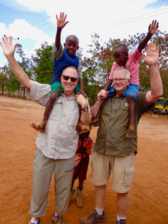 Photographer Tom Thompson and Tom Mac with children on shoulders at MCC. Marcia Moore