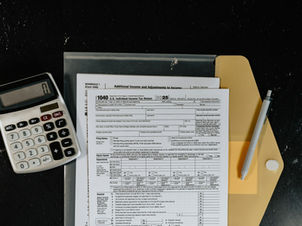 Taxpayer's tax forms and calculator on a desk, representing IRS Currently Not Collectible status review