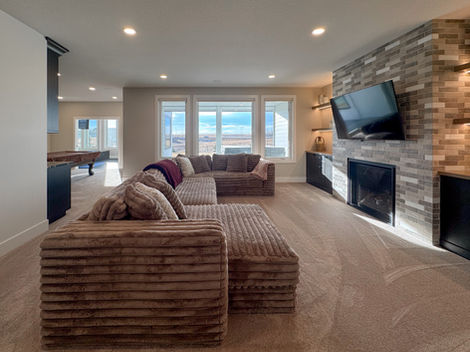 Modern living room with sectional sofa, fireplace, and large windows