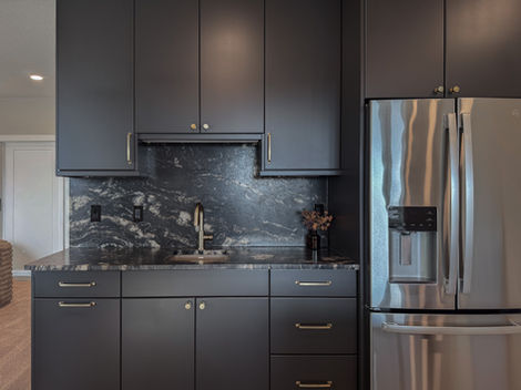 Wet bar with black marble and stainless steel fridge