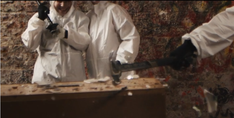Participants clad in protective gear joyfully demolish unsalvageable furniture in a rage room, smashing away stress and having a blast.