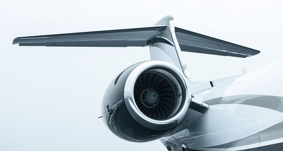 The tail and left engine of a Gulfstream aircraft with white, light & dark grey stripes