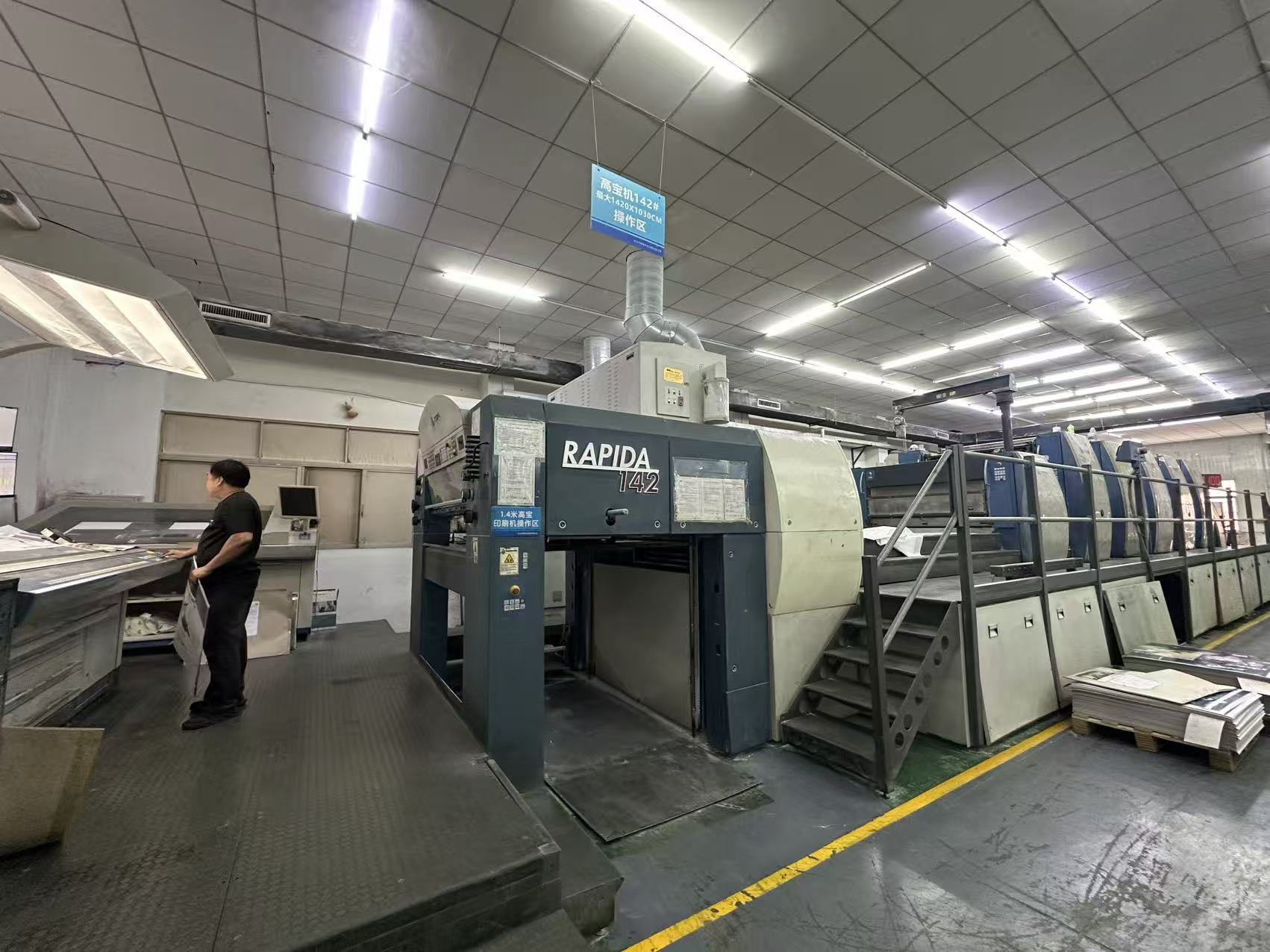 Printing press and operator inside the BOYA Printing workshop.