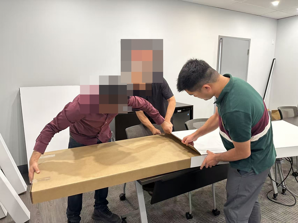 Three people reviewing a flat packaging sample; two customers' faces are obscured.