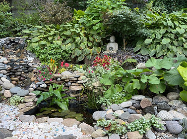 Peaceful water garden surrounded by flowers and sculpture spaces for personal and group retreats, relaxation, and reflection.