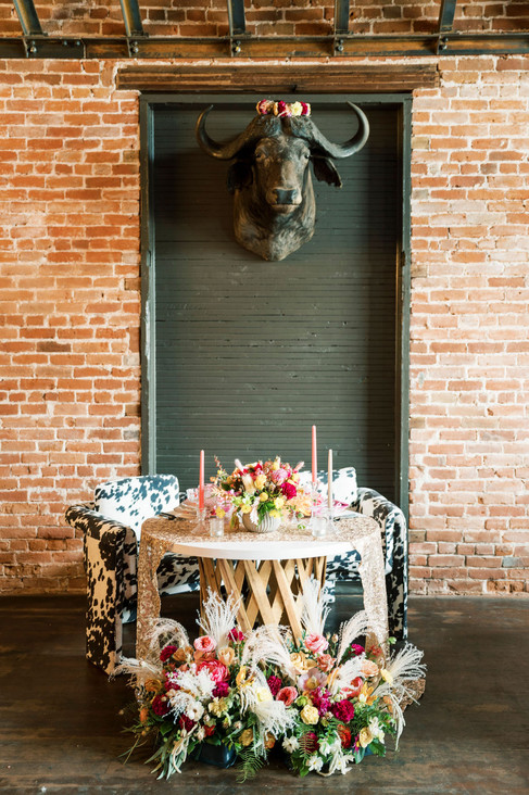 sweetheart table next to brick wall