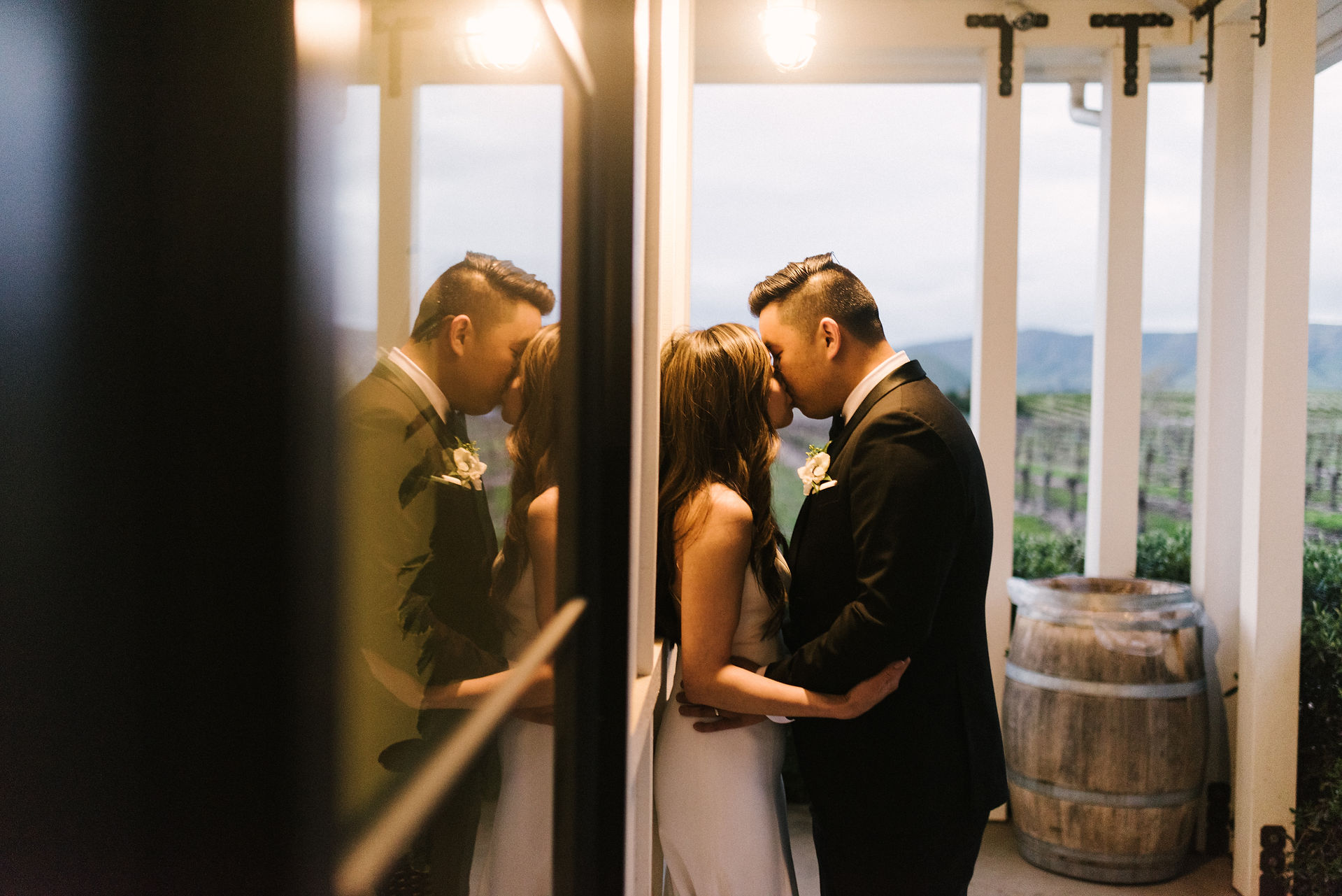 bride and groom kissing on porch