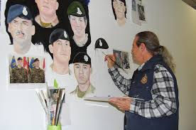 Dave standing in front of the mostly empty canvas, painting one of the portraits