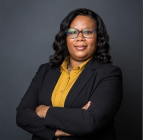 Professional portrait of a woman in a blazer on a neutral background, centered, portrait ratio.